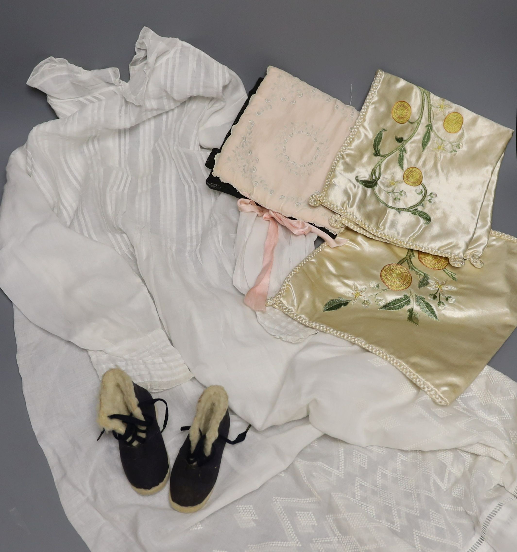 A pair of felt fur-lined child's boots and a whitework communion dress, a handkerchief sachet and two satin embroidered sachets